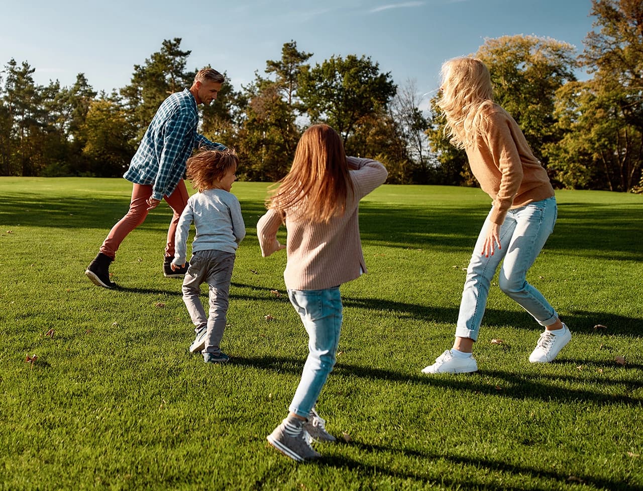 Happy family running around in a field